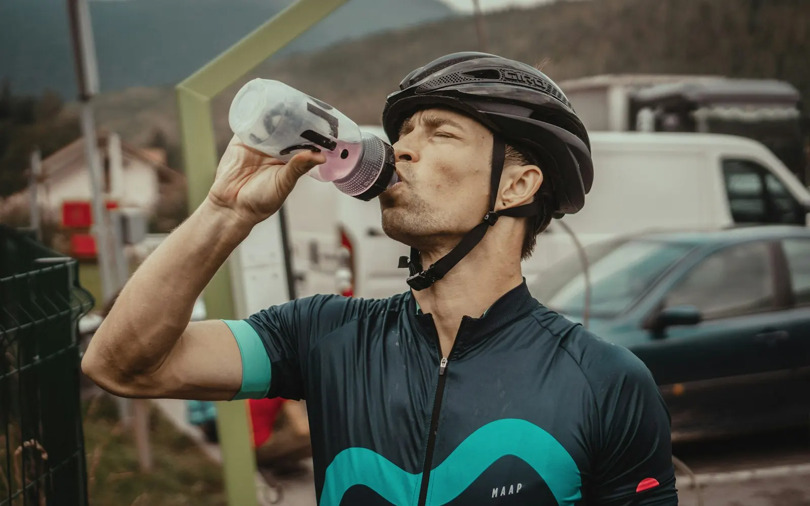 Cycliste casqué qui boit à son bidon pendant une sortie