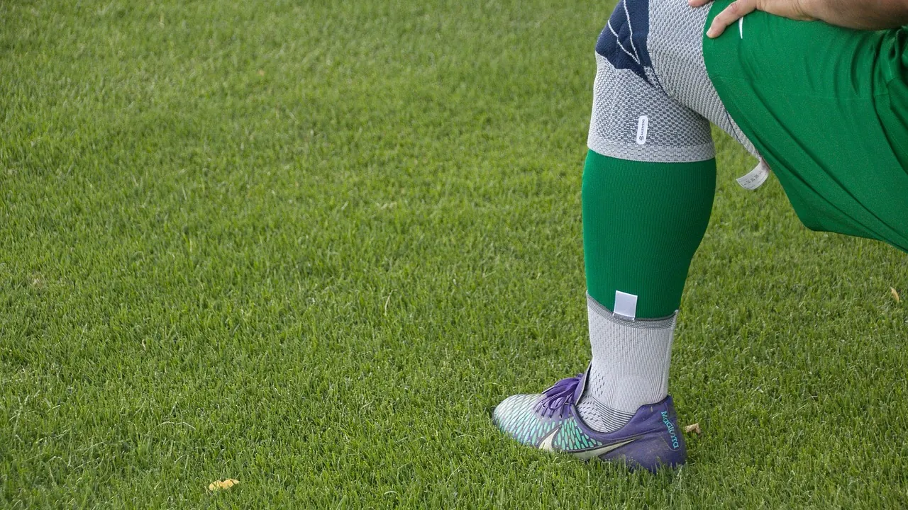 Footballeur qui se tient le genou sur le terrain