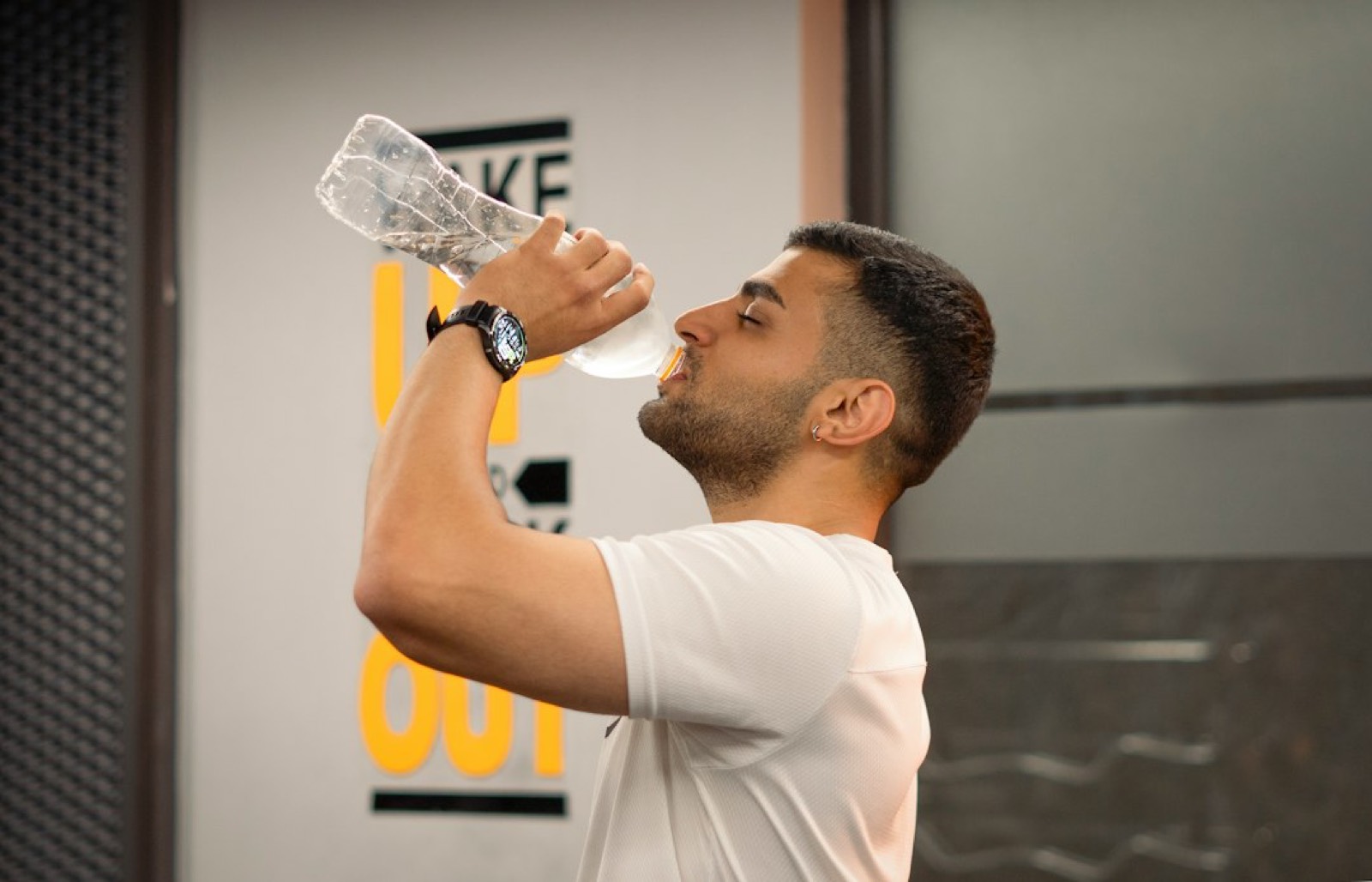 Sportif qui s'étire avec une bouteille d'eau après l'effort