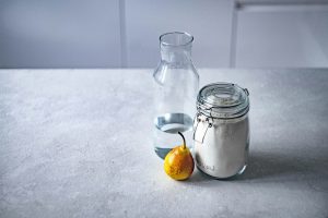 Bouteille d'eau, citron et bocal de sucre pour une boisson maison