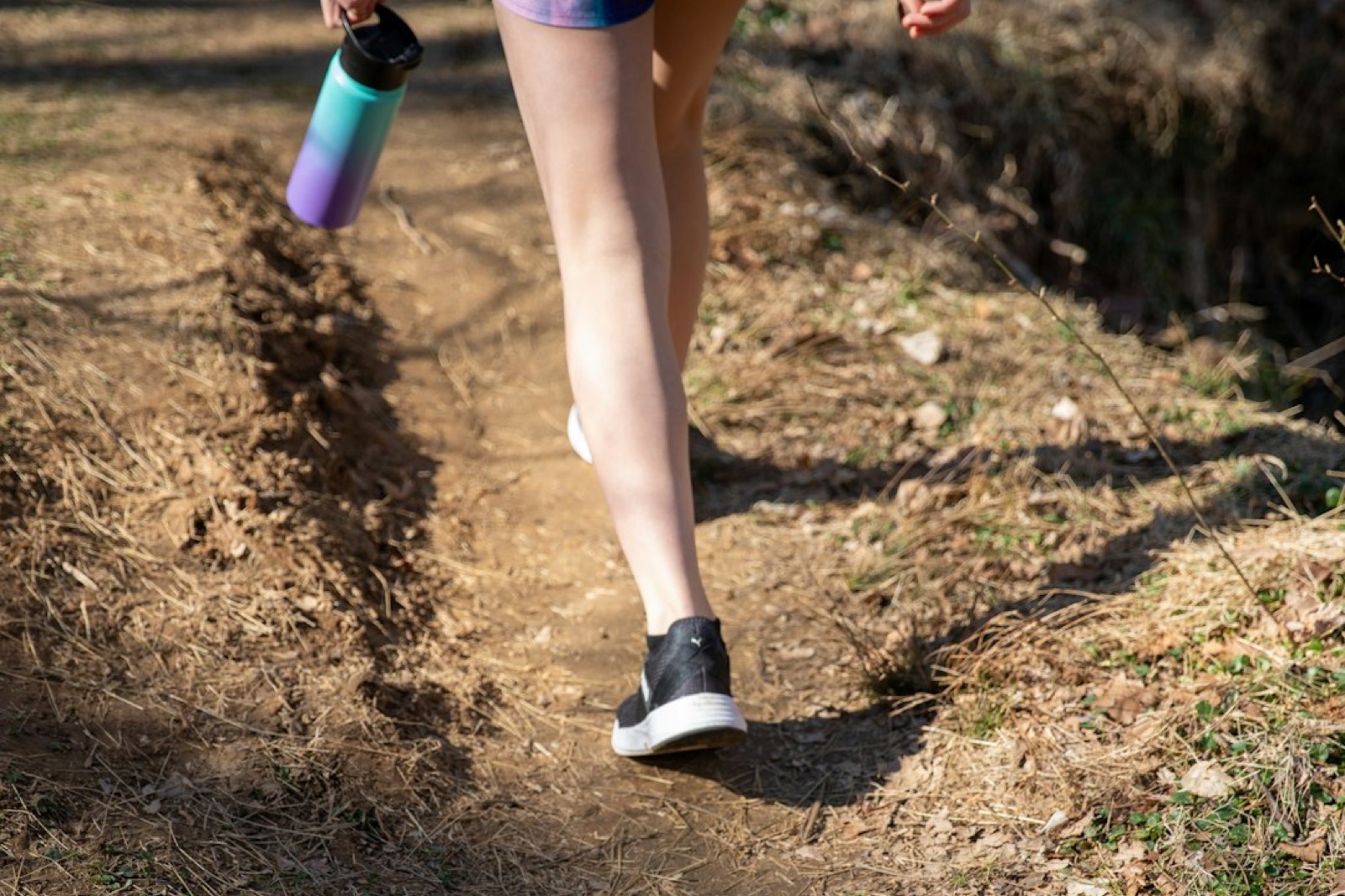 Coureur s'étirant avec une bouteille d'eau après une séance de sport